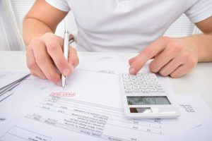 Man calculating money owed on past due bills